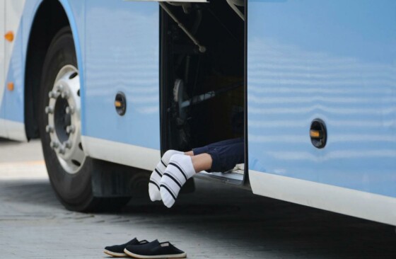 یک راننده اتوبوس در یک روز گرم در محفظه بار استراحت می‌کند. عکس: اندی وانگ/ای‌پی