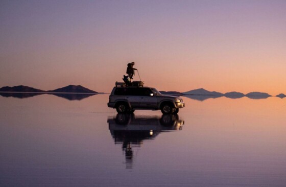 گردشگران در حال تماشای غروب خورشید در دشت نمکی اویونی هستند که بیش از ۱۰۰۰۰ کیلومتر مربع مساحت دارد و بزرگترین چشم‌انداز از این نوع در جهان است.