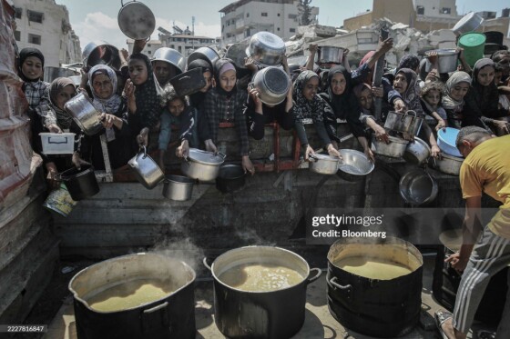 فلسطینی‌ها روز دوشنبه، ۴ آگوست ۲۰۲۵، قابلمه‌ها و ماهیتابه‌های خود را برای جمع‌آوری غذای رایگان از یک آشپزخانه خیریه در شهر غزه، غزه، بالا گرفته‌اند
