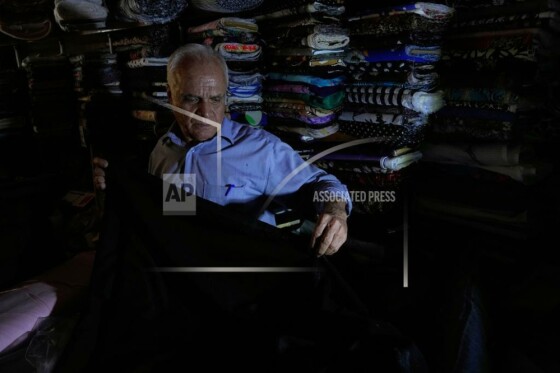 یک فروشنده پارچه در مغازه خود در هنگام قطعی برق در تهران، ایران، سه‌شنبه، ۵ آگوست ۲۰۲۵، کار می‌کند.