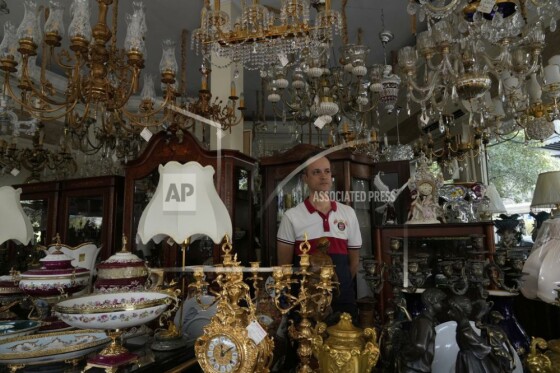 فروشنده لوستر و اقلام تزئینی در مغازه خود در هنگام قطعی برق در تهران، ایران، سه‌شنبه، ۵ آگوست ۲۰۲۵ ایستاده است.