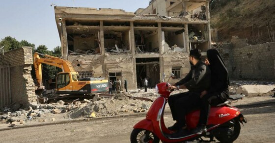 مردم سوار بر موتورسیکلت هستند و این منظره، پیامدهای حمله اسرائیل به زندان اوین را که در ۲۳ ژوئن، پس از آتش‌بس بین اسرائیل و ایران، در تهران، ایران، در ۲۹ ژوئن ۲۰۲۵ رخ داد، نشان می‌دهد.